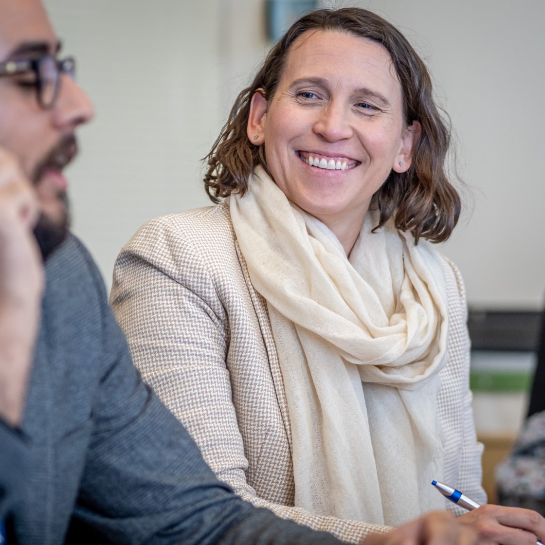 woman smiles at man speaking next to her