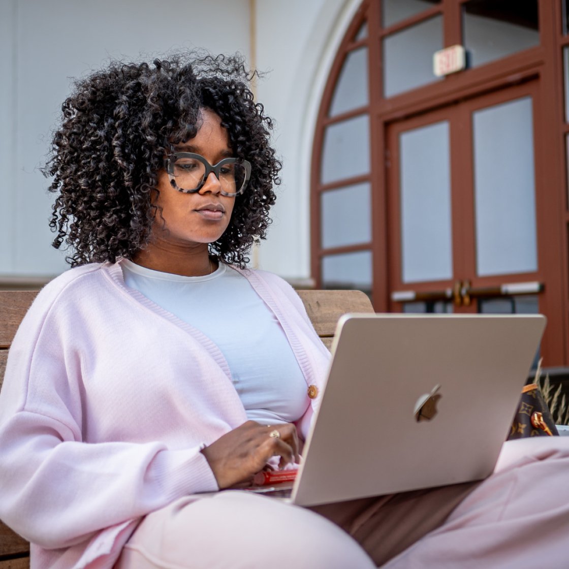 Student sitting on a bench with a laptop