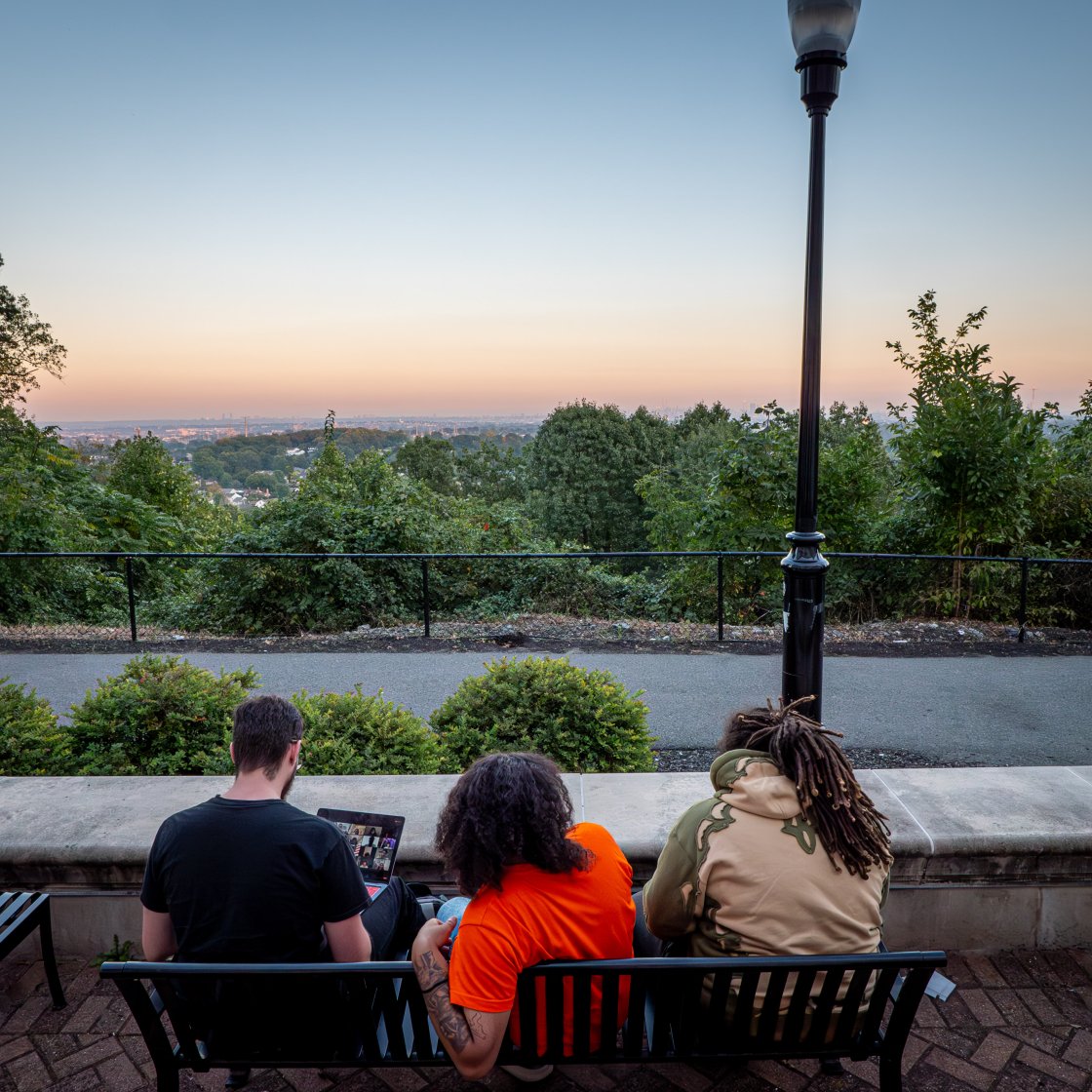 students sitting in front of NYC skyline