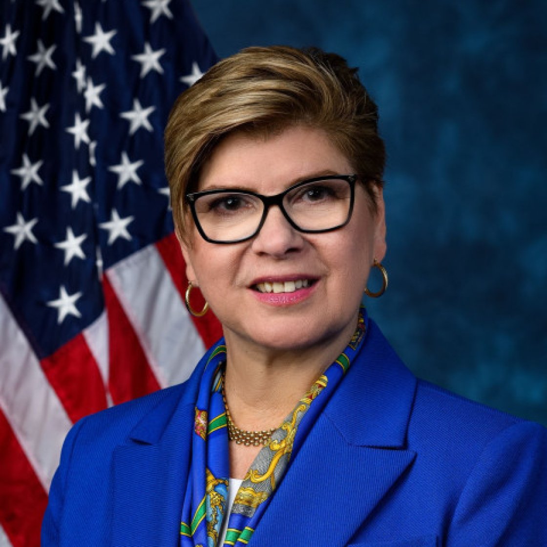 headshot of Nellie Pou in front of American flag