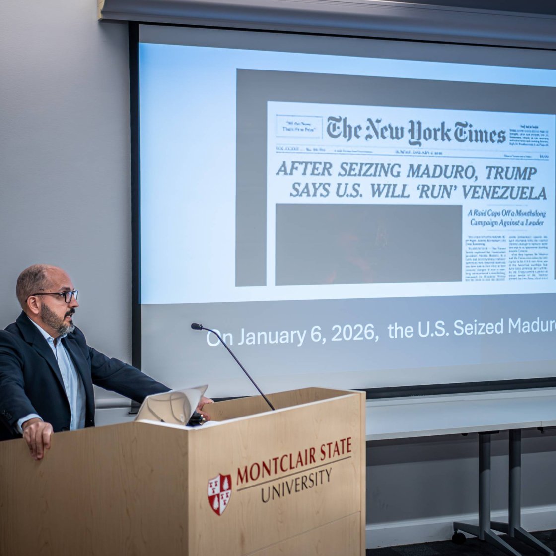 A professor stands in front of a PowerPoint detailing a New York Times article