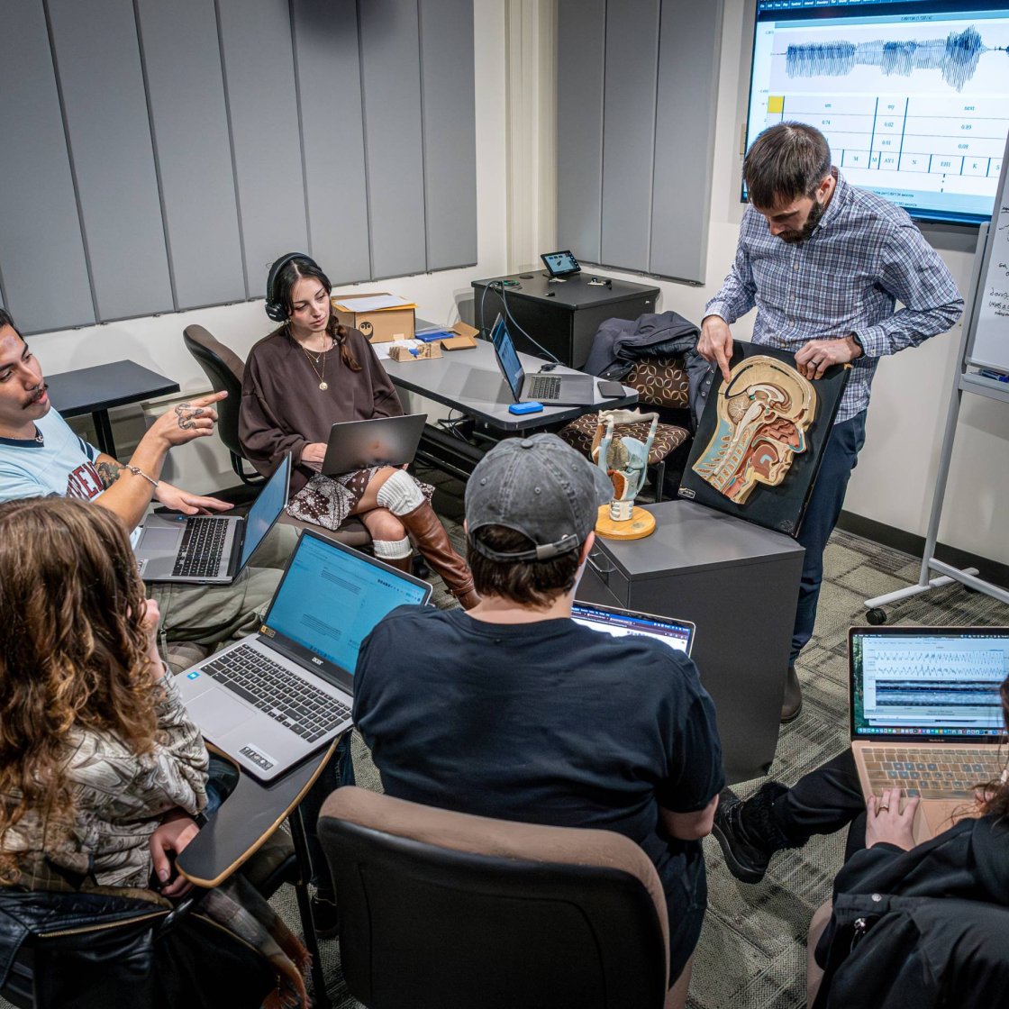 Professor leading a classroom demonstration while students watch