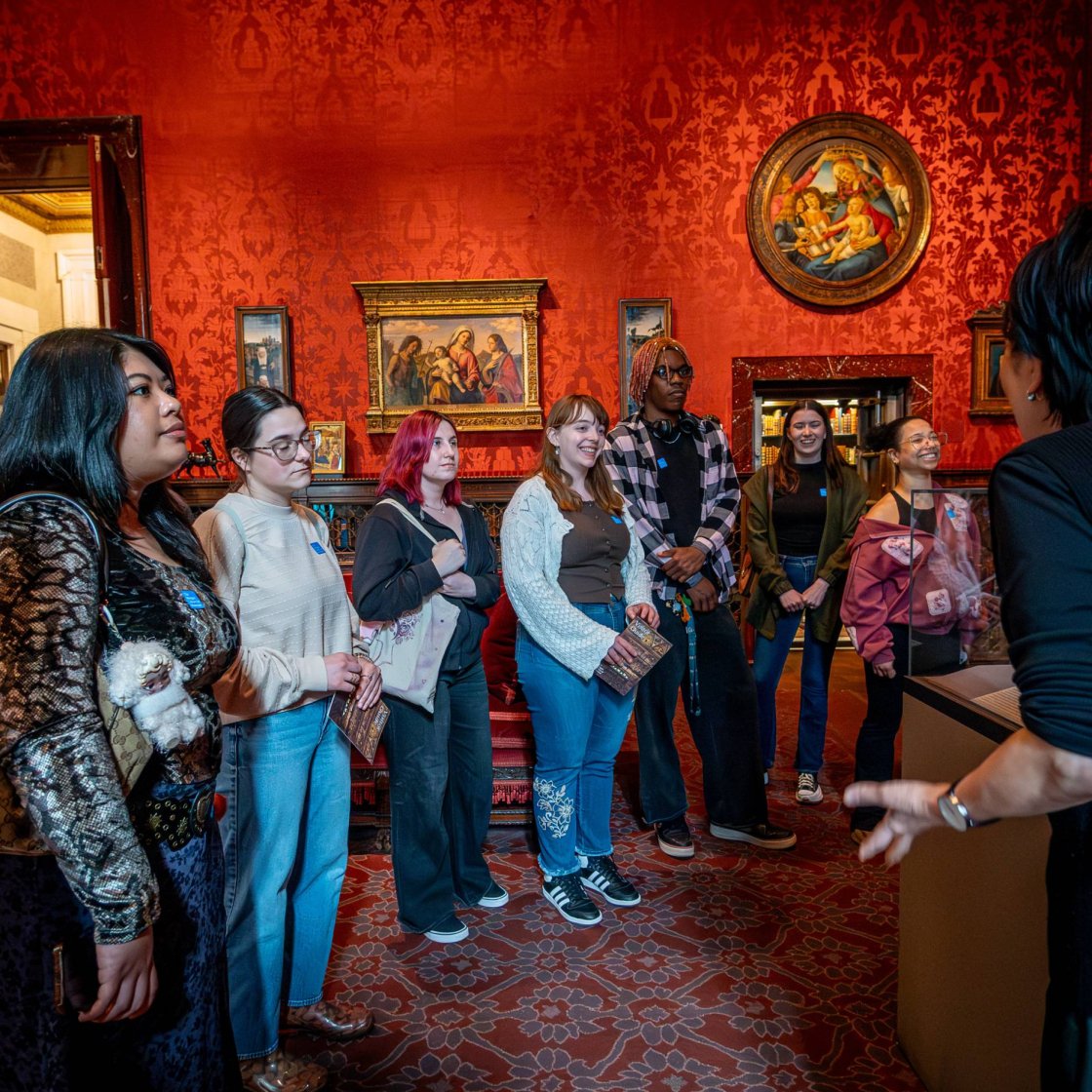 A docent leads a tour of college students through a history museum