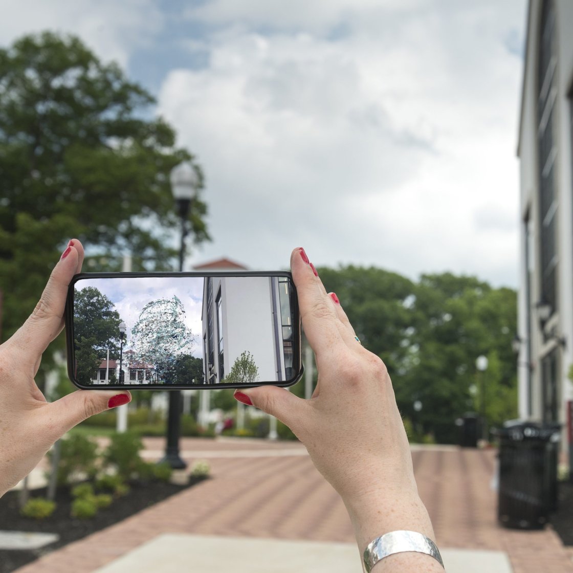 Person taking a photo with a cell phone near University Galleries