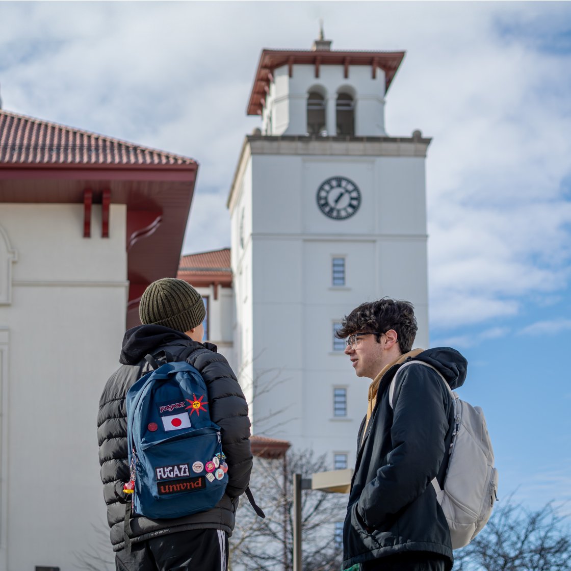 two students chatting outside of university hall. 