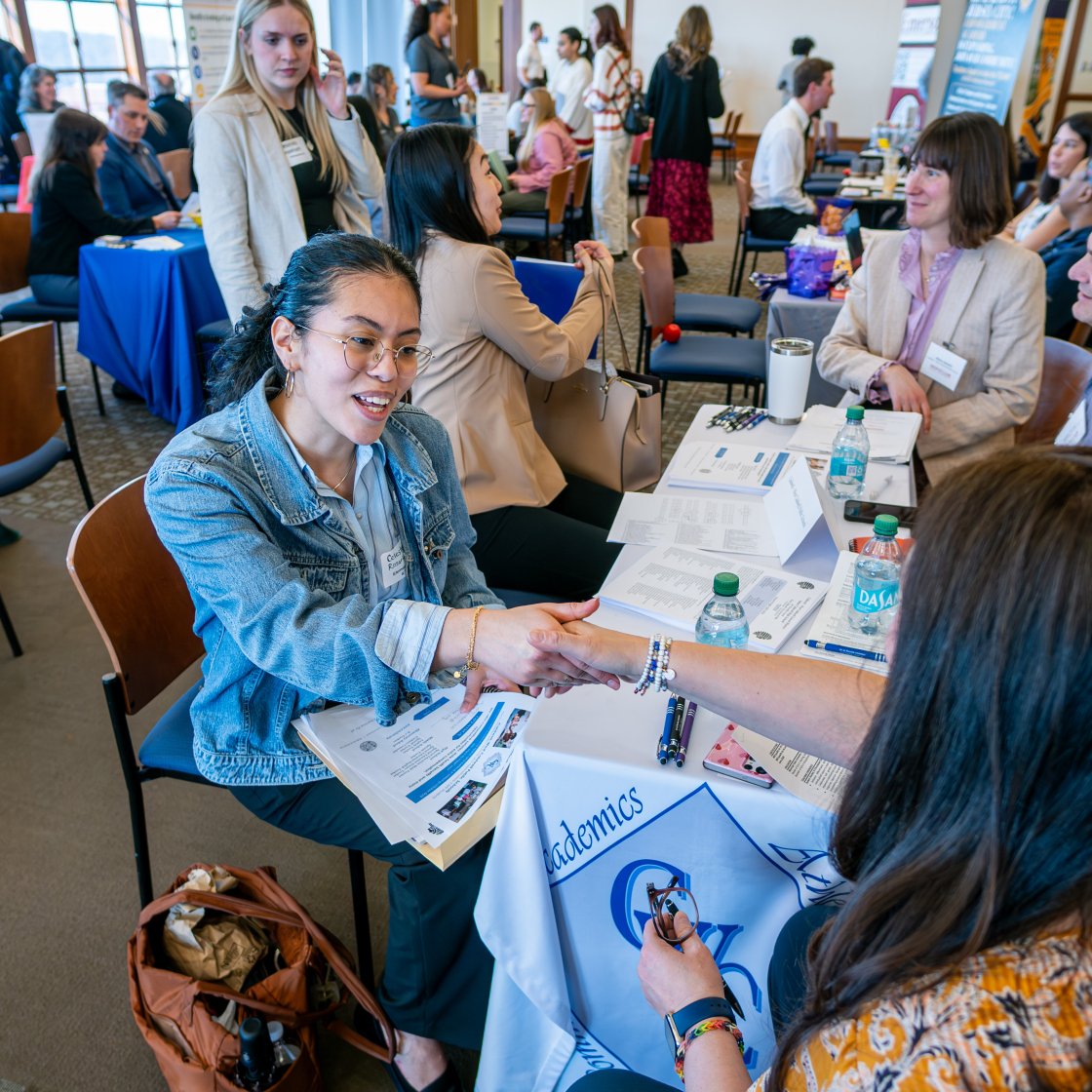 a student interviewer shakes the hand of an employer