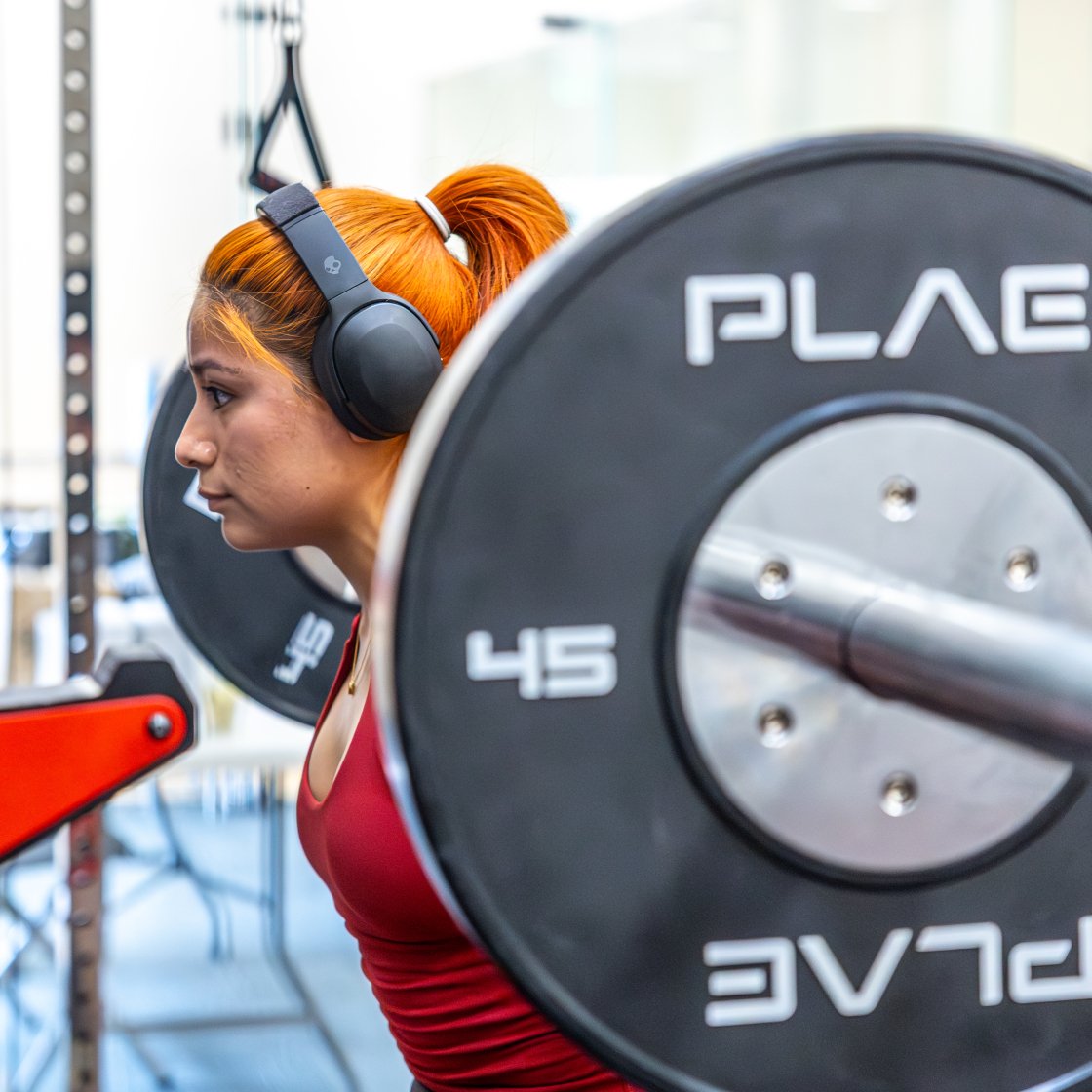 student benching a 45 lb weight