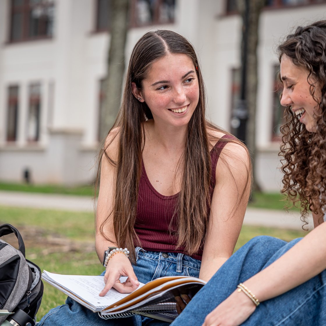 Two students on the quad sitting 
