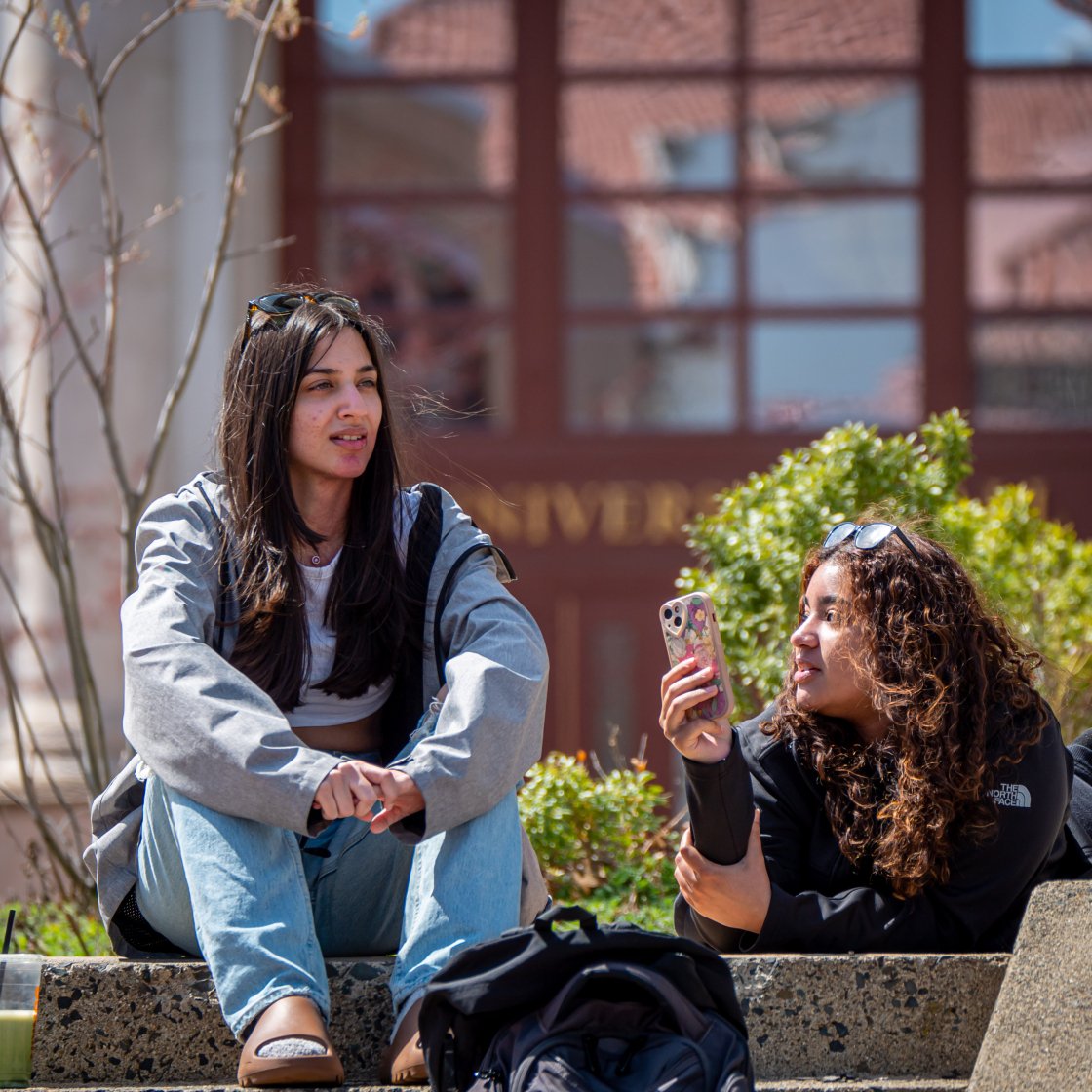 students talking on university hall steps
