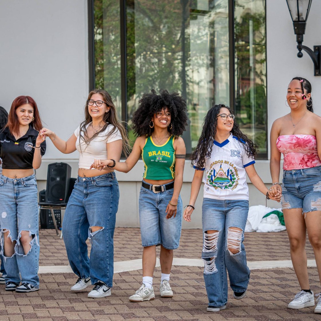 A group of college students take a bow after an outdoor performance