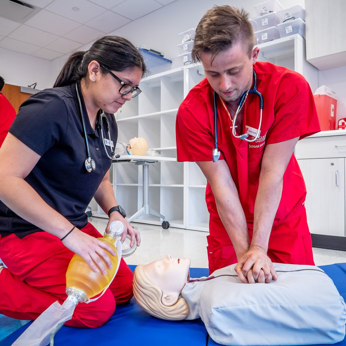 Nursing students demonstrating CPR on a patient care manikin.