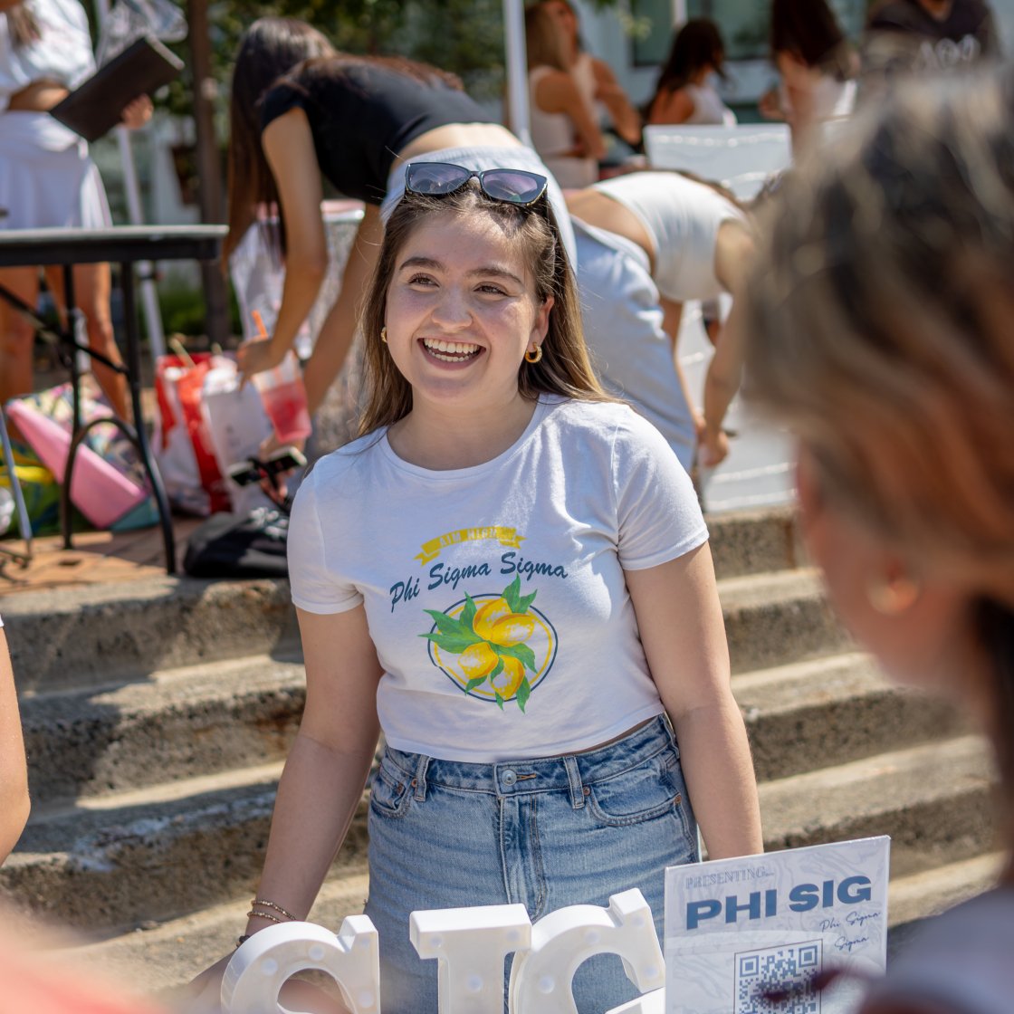 greek student at a tabling event smiling