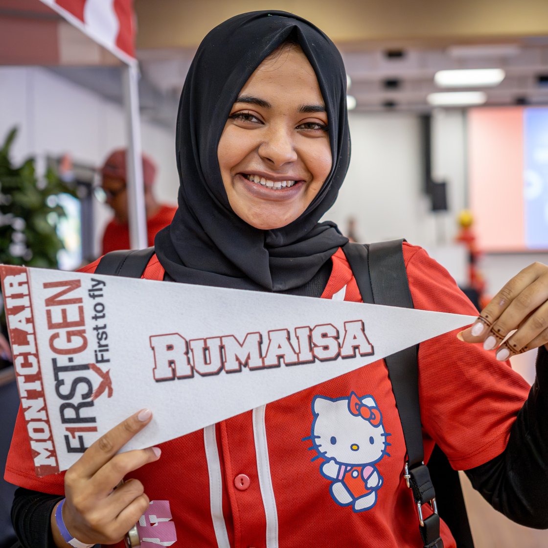 student holding up their personalized first gen flag