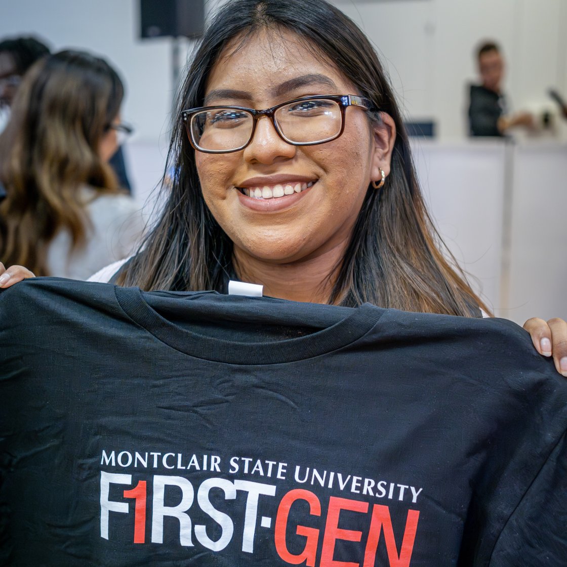 student holding up first gen shirt