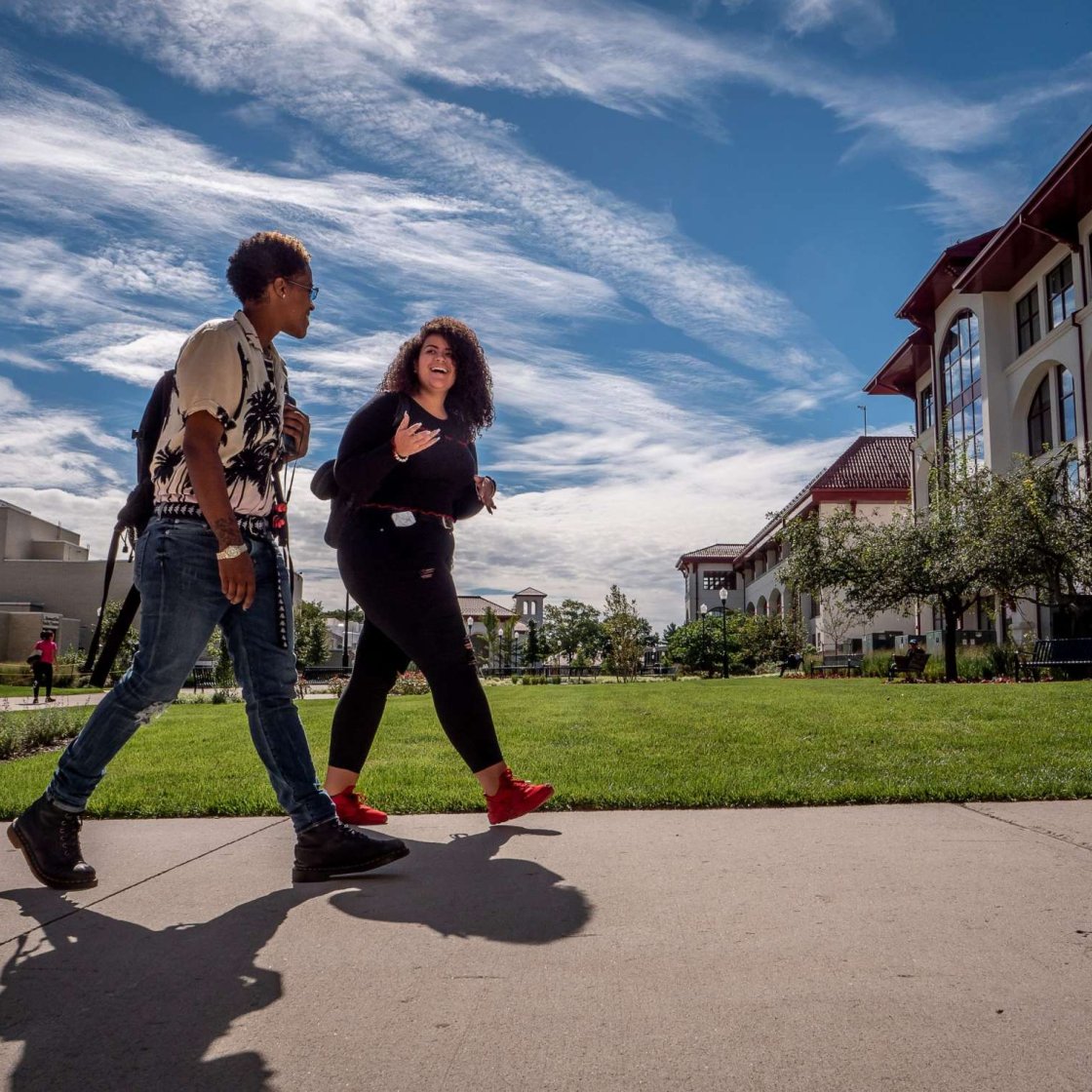 two students speaking and walking to class together