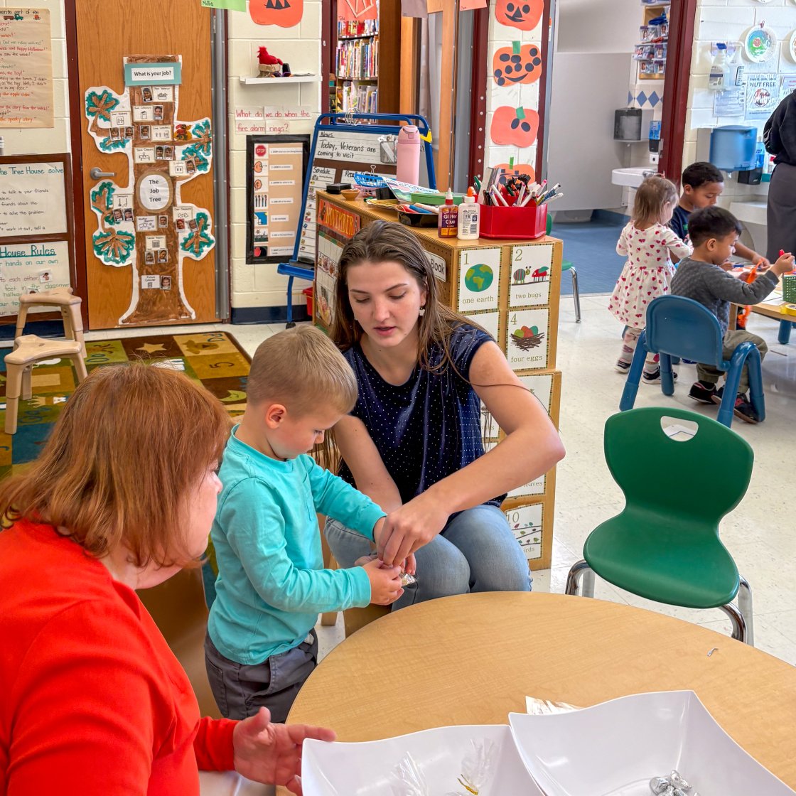 a teacher helps a student with a Veterans Day project