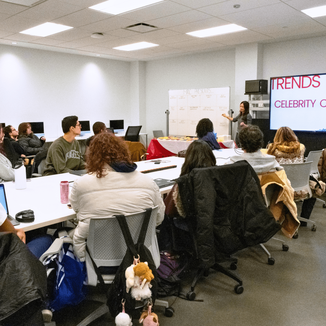 Students in a classroom listening to a student presenting.