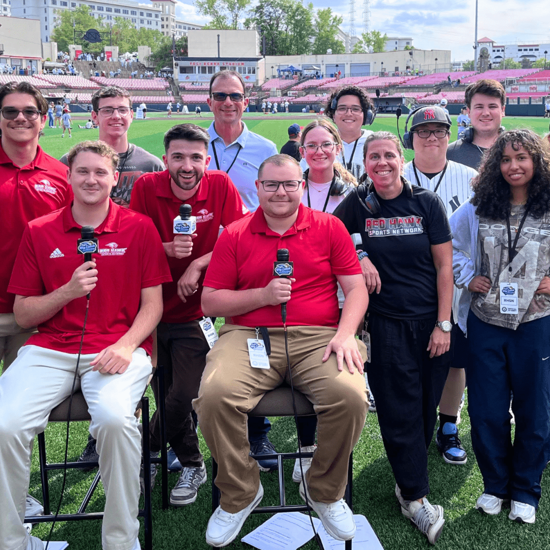 Red Hawk Sports Network students pose for a group photo on the field.