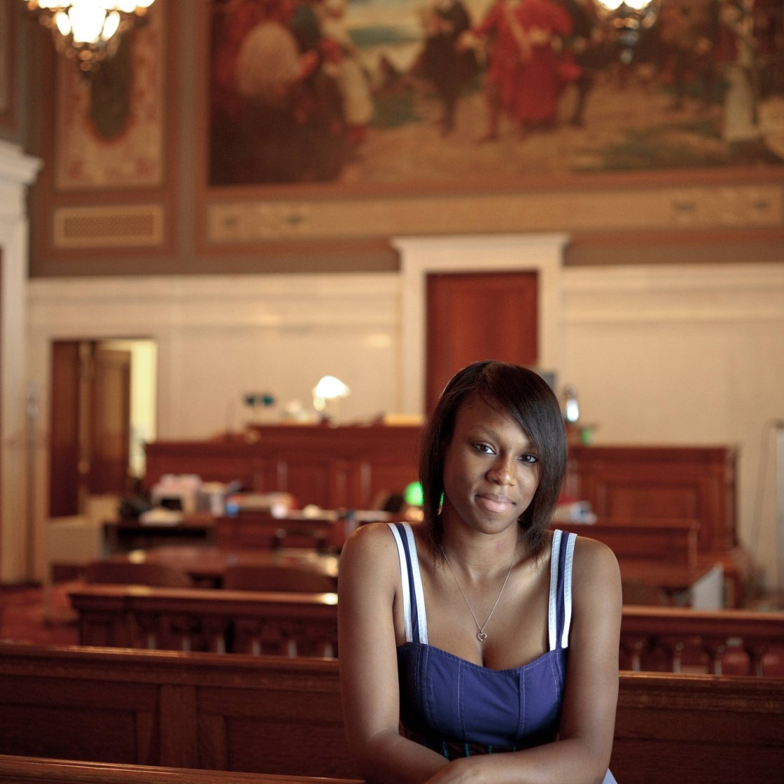 A student leans on a pew inside a courtroom