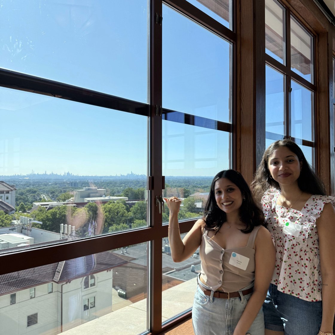 A picture of two students standing by a window overlooking Montclair's campus