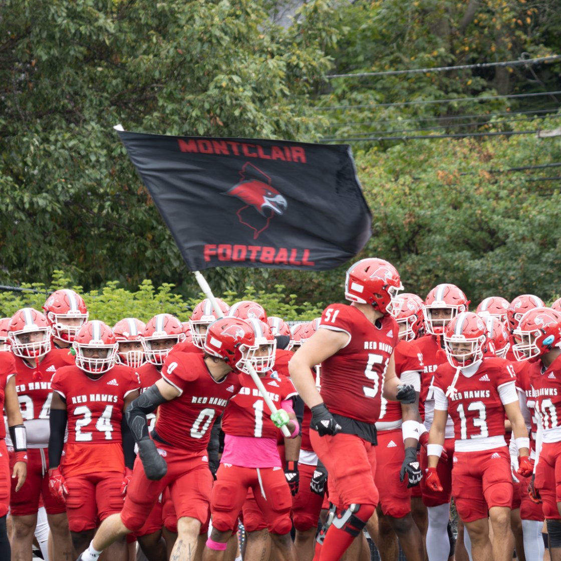 Montclair Football Team at Homecoming waving team flag.