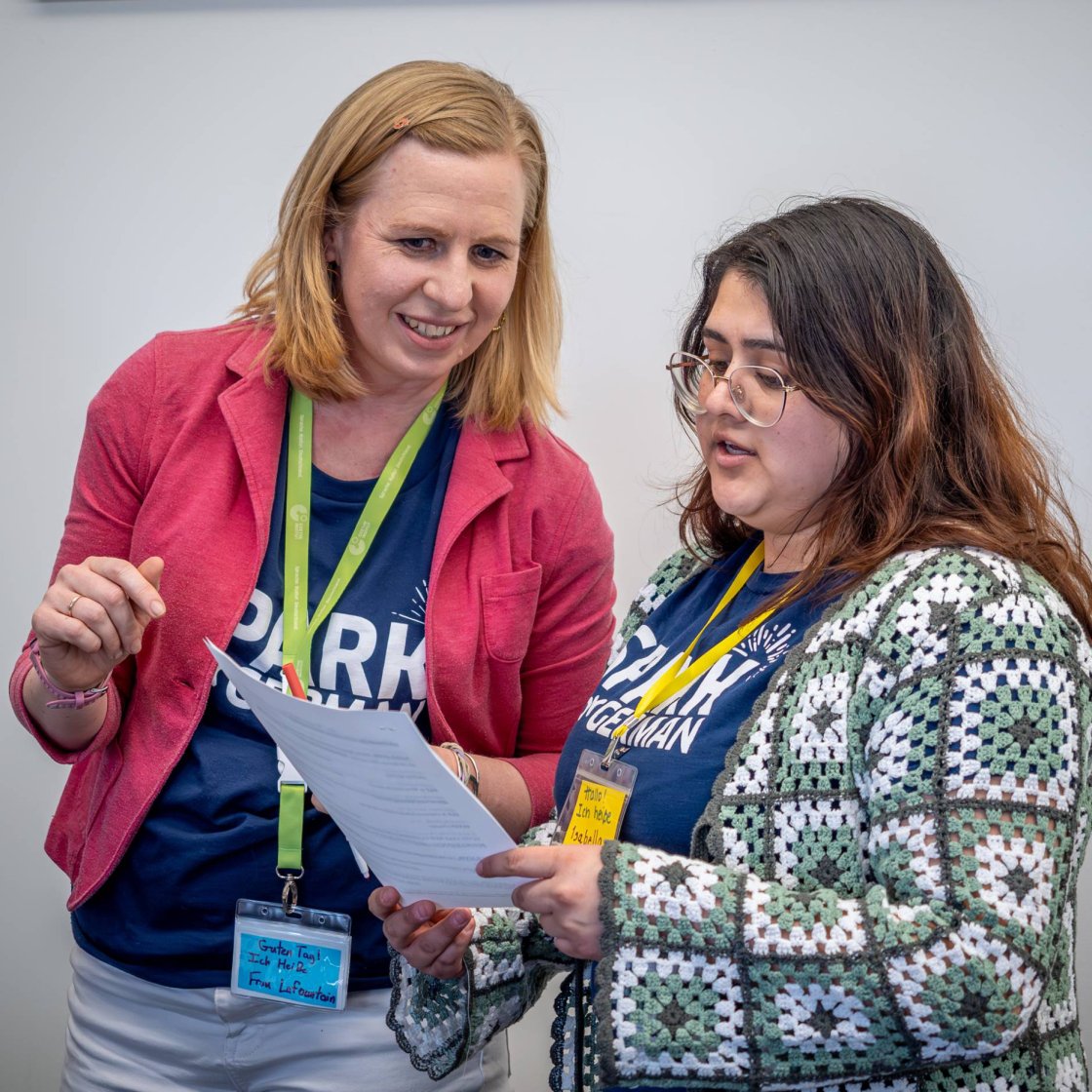 Two people look at a paper and discuss it