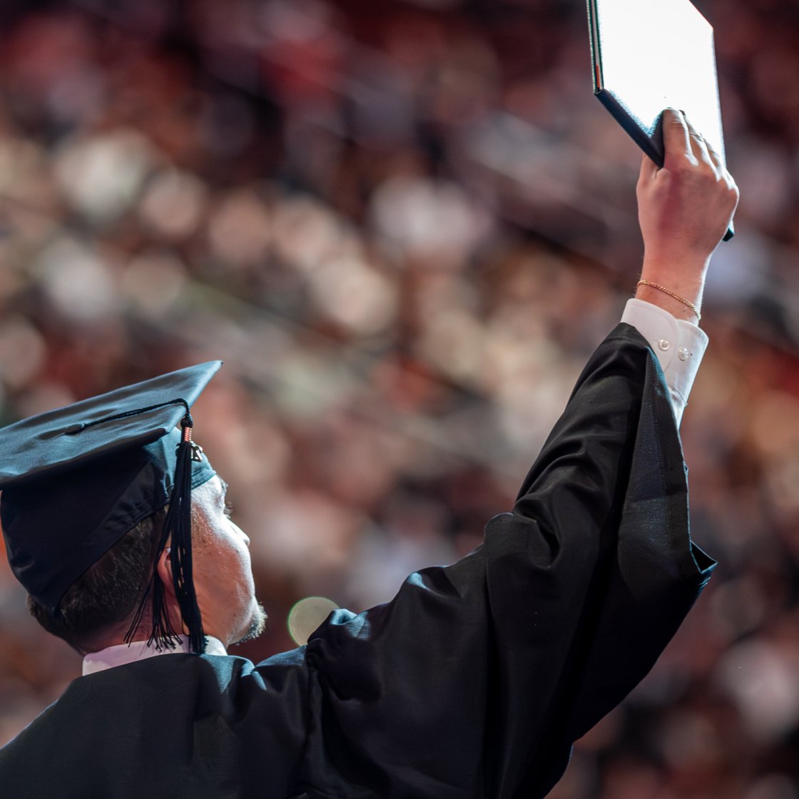 Graduate raises diploma to crowd