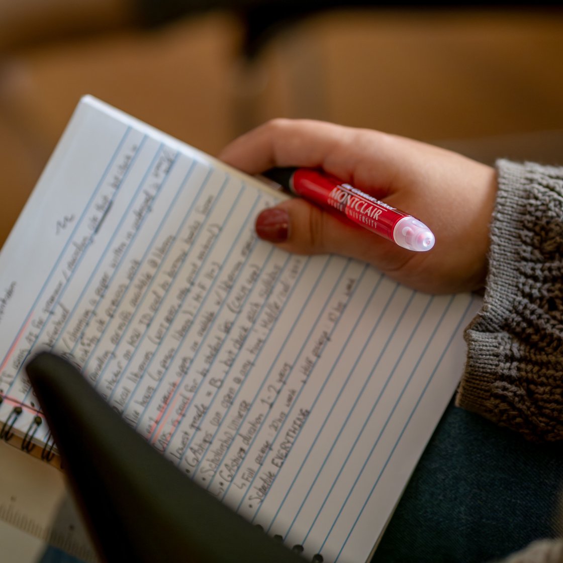 A woman holding a pen and notepad 