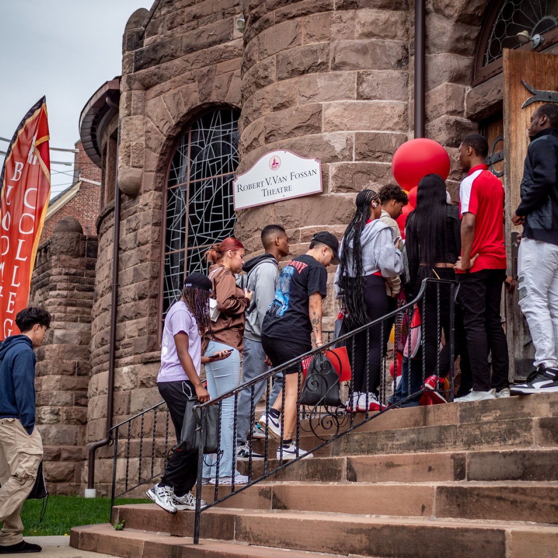 Students walking up stairs into a building