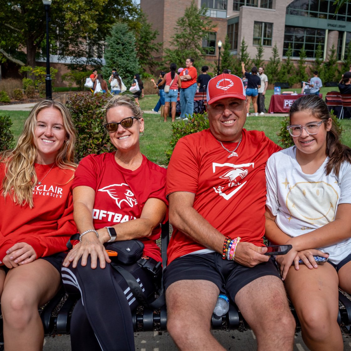 A family of four sitting on a bench 