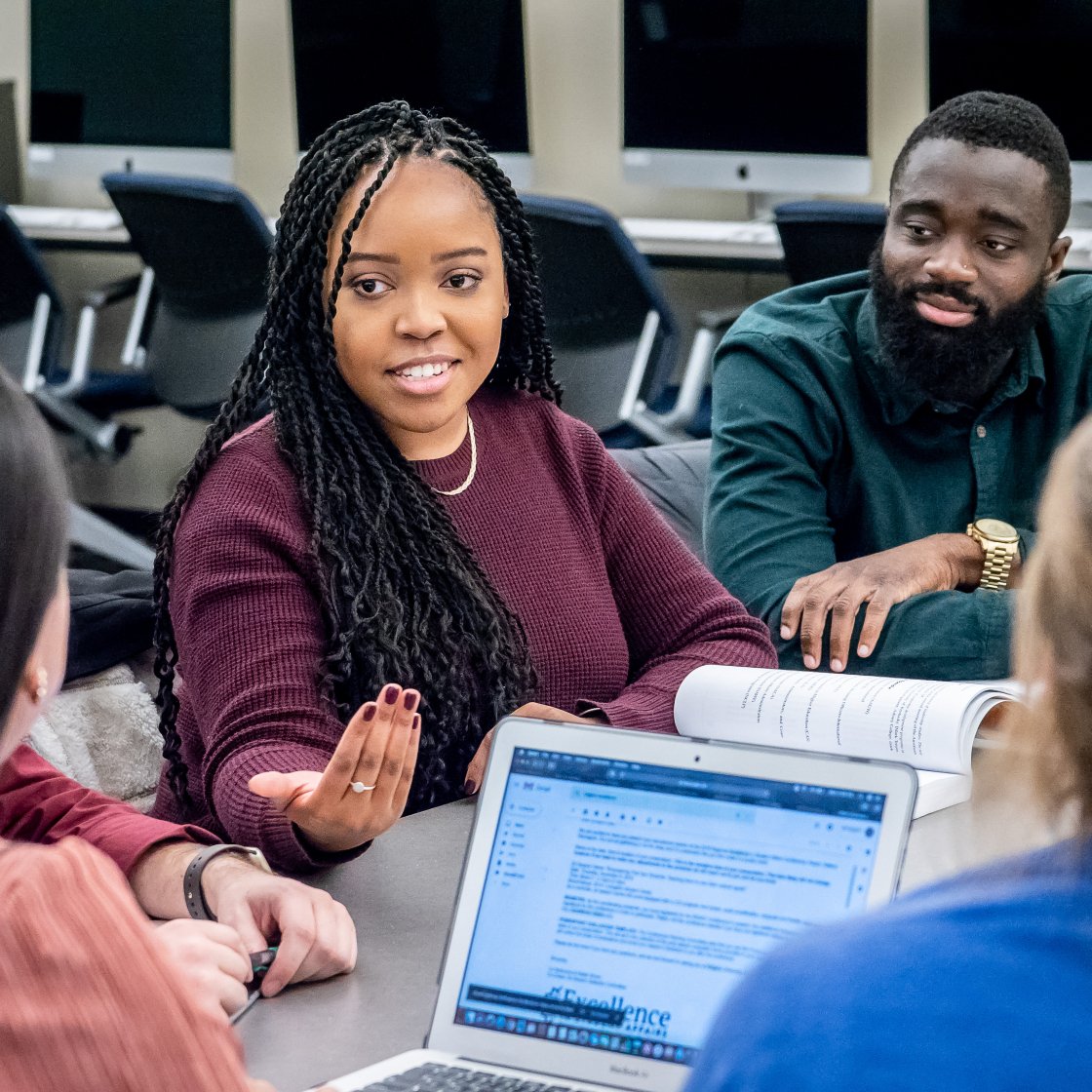 a group of students have a discussion at a table