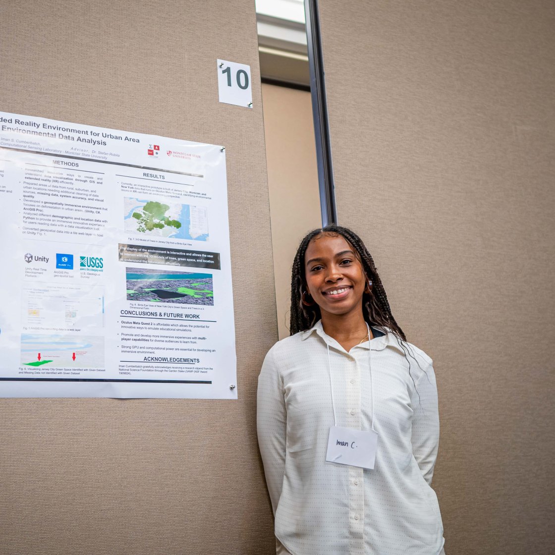 Student stands beside a research poster presentation.