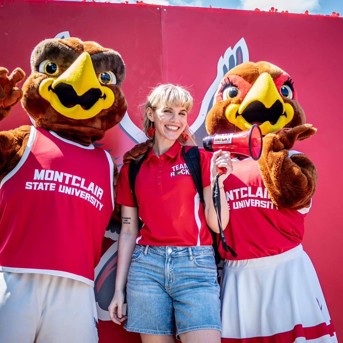 Student poses with Rocky and Roxy at orientation.