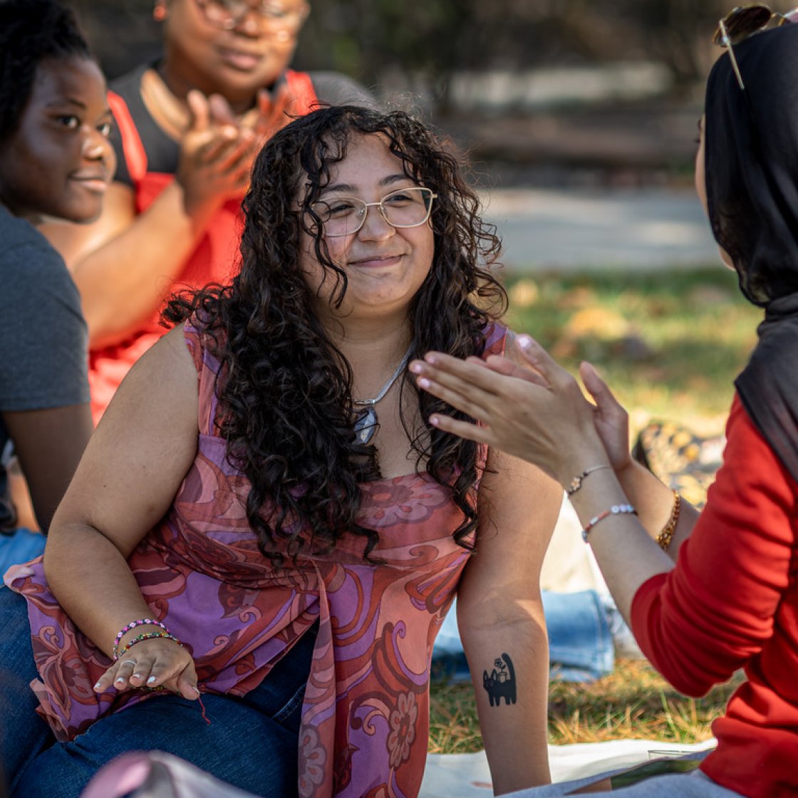 Students laughing and smiling at a picnic outside Cole Hall.