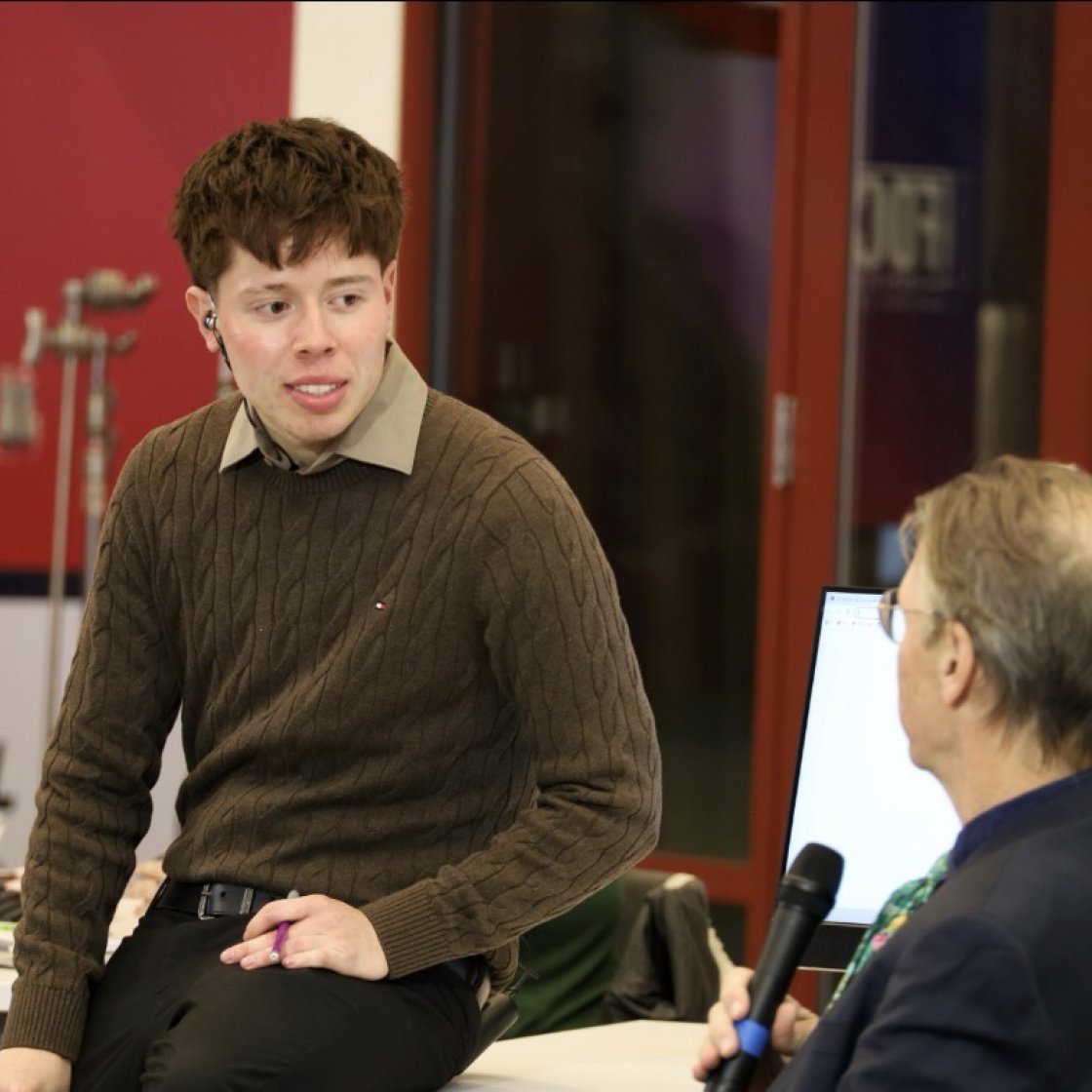 Student speaking to professor for FOCUS production in our newsroom.