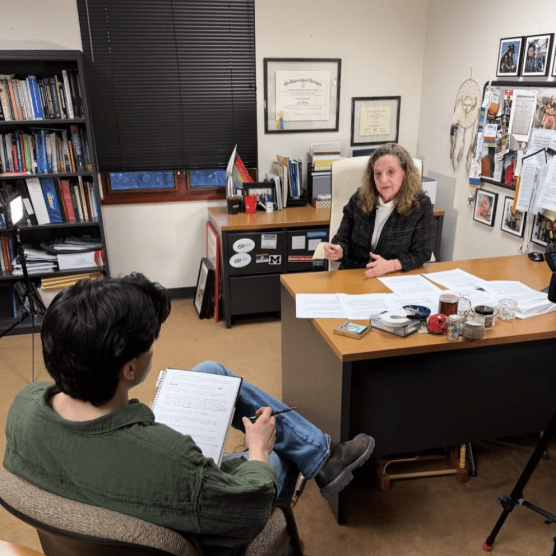 Student conducting interview in subject's office.