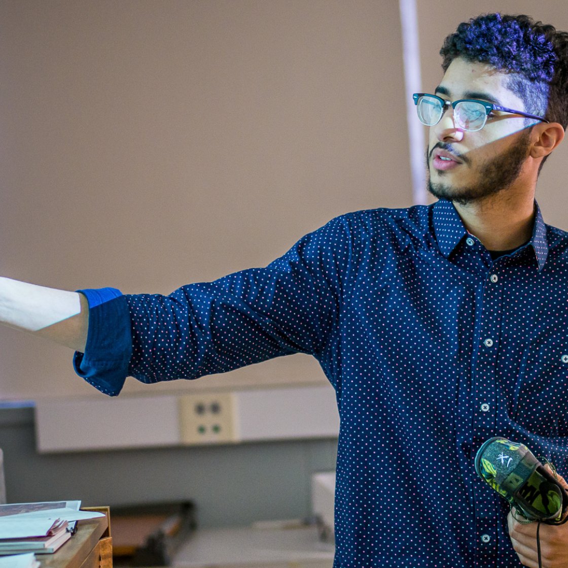A student pointing at a screen projection