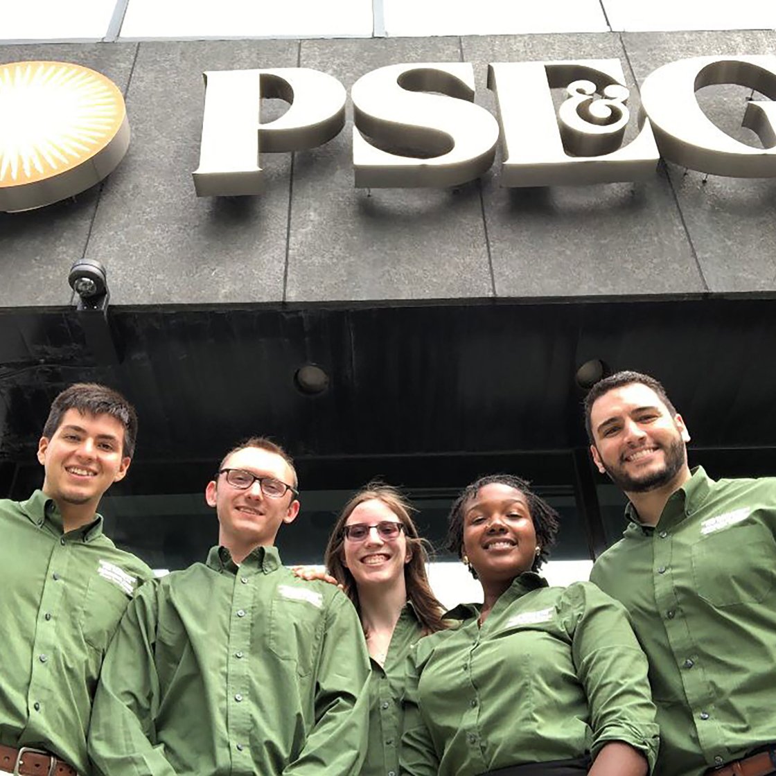 Students smiling in front of PSEG sign