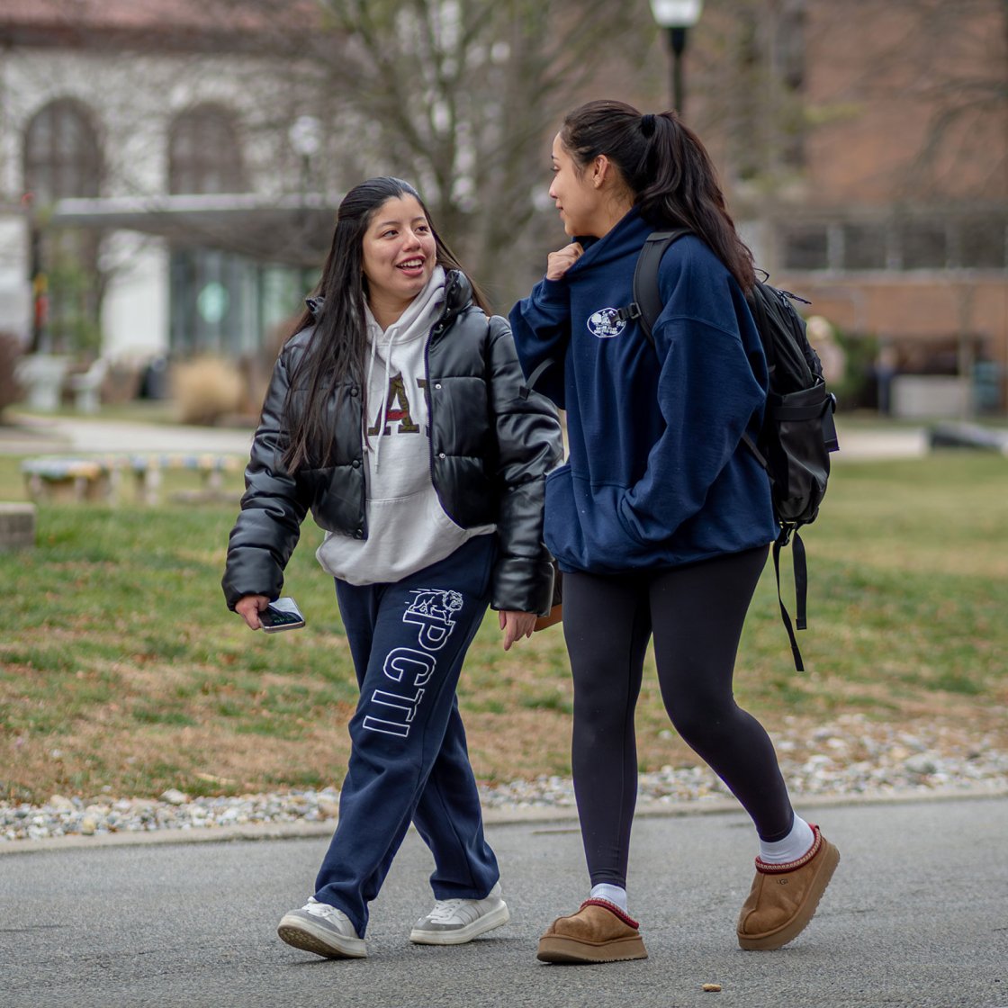 two students walking along the quad, talking