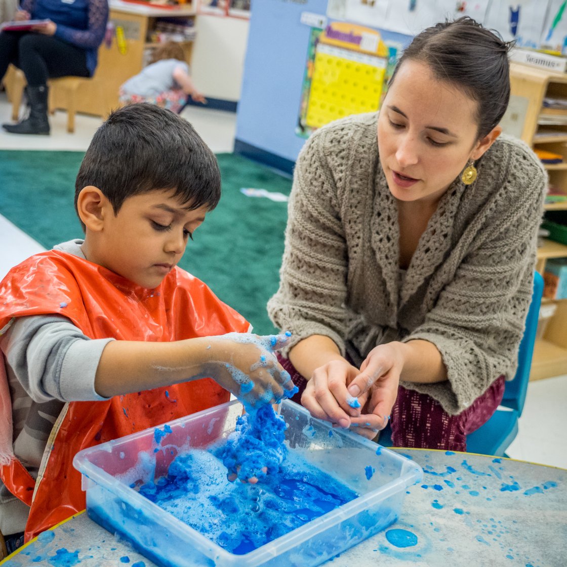 a teacher works with a student at a sensory station
