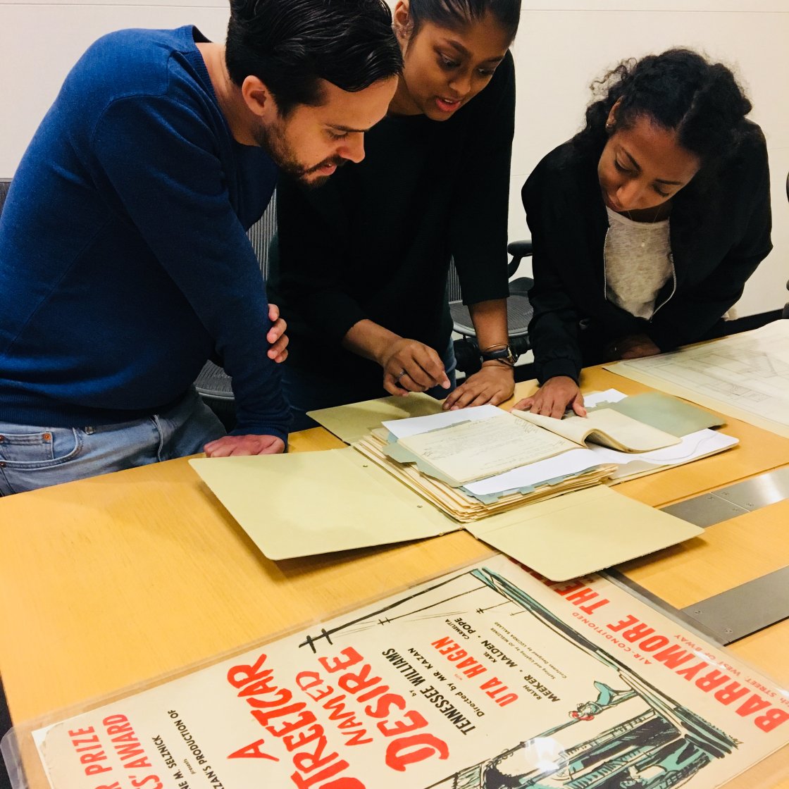 Three people at a table talking and studying