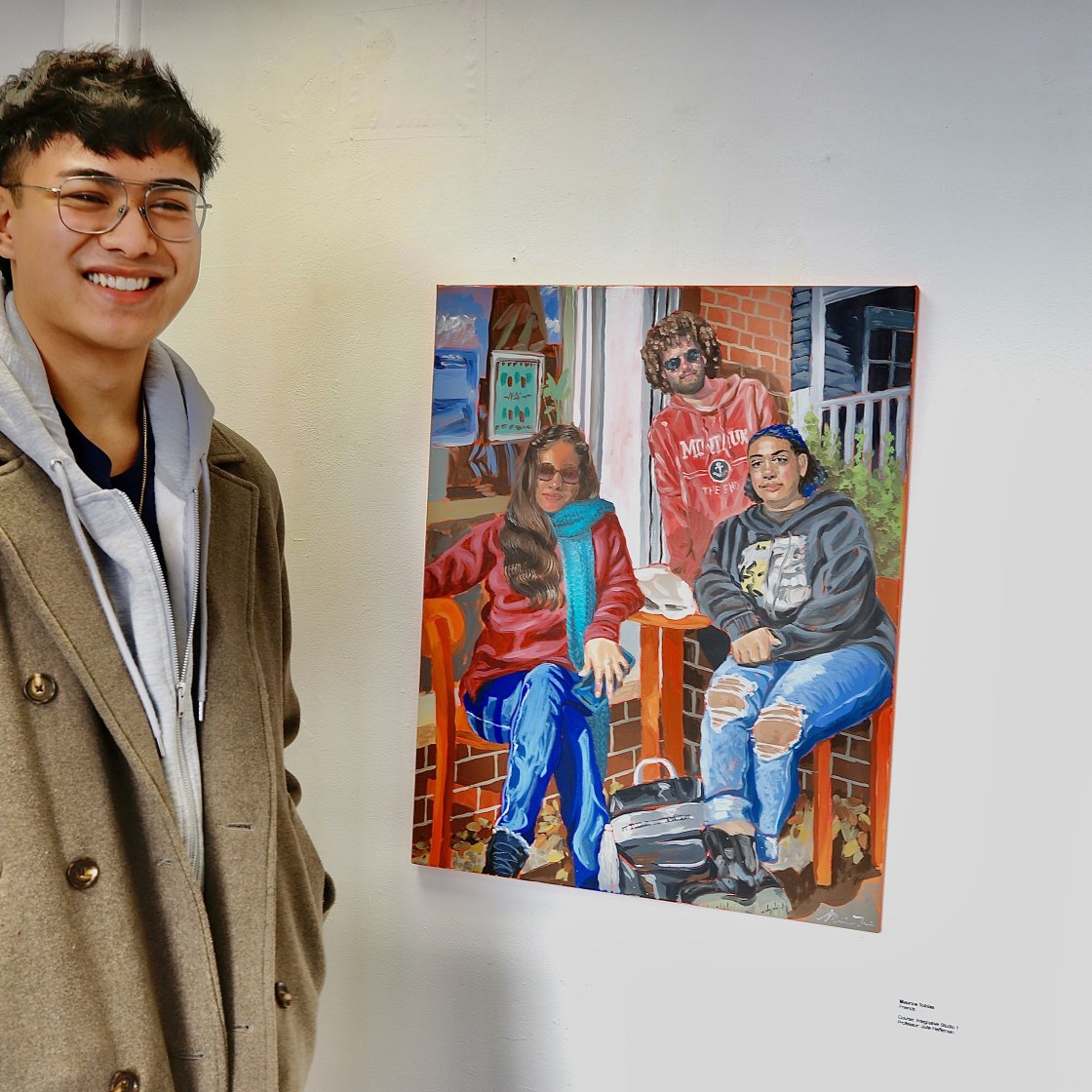 Student standing next to artwork in Finley Gallery