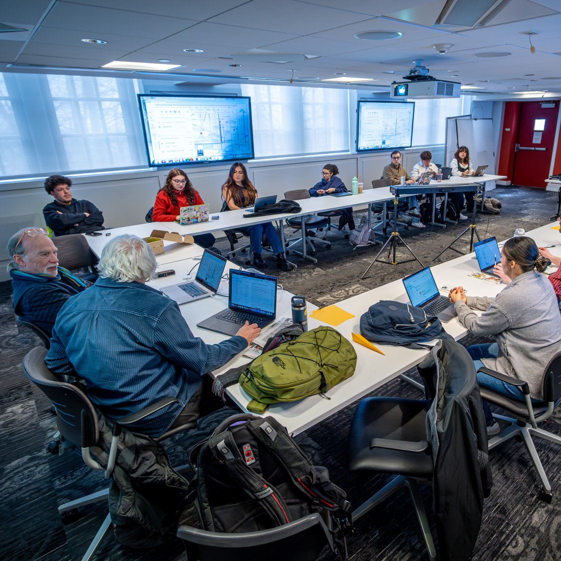Students sit around a table with their instructor.
