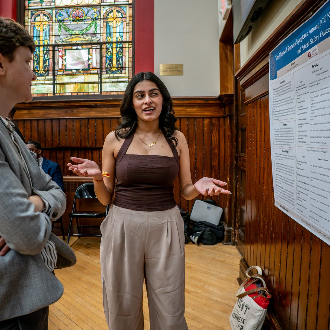 Two women standing in front of poster