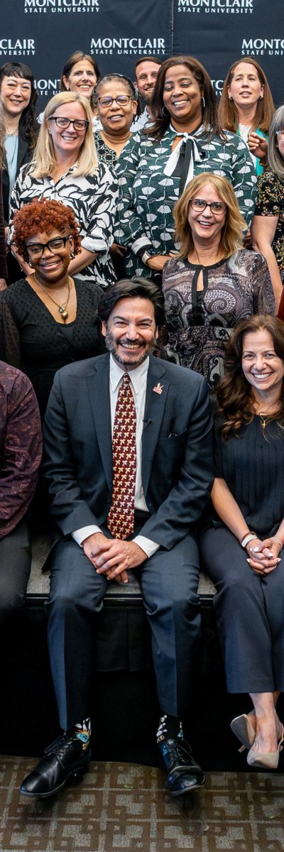 Three rows of Presidential Excellence Award winning employees posing for a seated group photo.