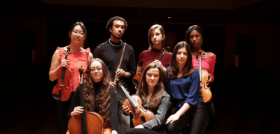 Group of music students holding instruments on stage