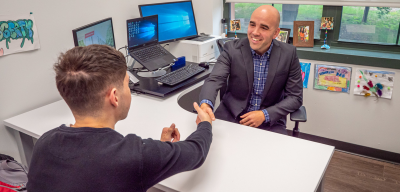 Student shaking hands with his academic advisor during an advising appointment.