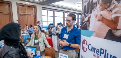 A career services fair where a man conversing with a student.
