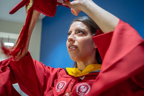 Andrea Uguna-Solano puts on her mortarboard.