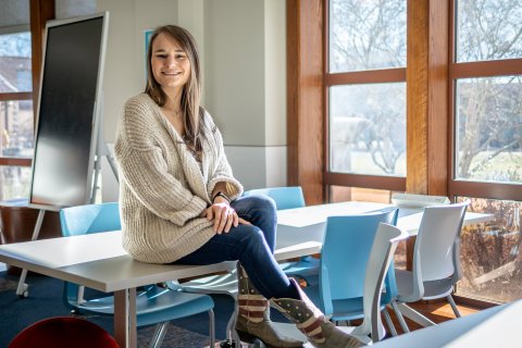 Alex Hatala sitting atop a classroom desk